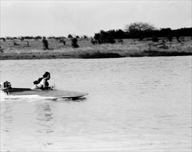 Mrs Archer pilots a speedboat. Mrs Archer scuds across a lake in a small speedboat during a race at