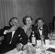 Partying at the SJAK dance. A group dressed in formal evening wear raise their glasses at a dance
