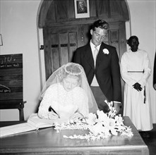 June Watkin signs the register. Bride June Watkin signs the marriage register in the presence of