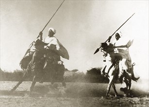 North Sudanese warriors on horseback. Two Sudanese warriors wearing white robes and turbans ride