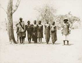 Balanda chief and wives. A Balanda chief and his deputy with their six wives. Both men wear