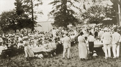 Naval lunch at Pietermaritzberg. A large crowd of men and boys dressed in white naval uniforms sit