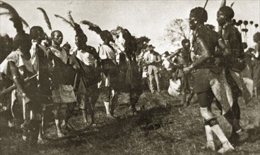African dancers in costume. A group of African men dressed in ceremonial costume and feathered