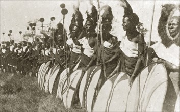 Chiefs prepare for a 'ngoma'. A group of African chiefs dressed in ceremonial costume hold sticks