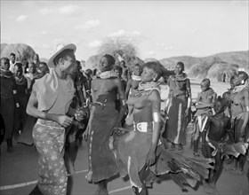 A Turkana 'ngoma'. A crowd of onlookers watch a Turkana man and two Turkana women wearing