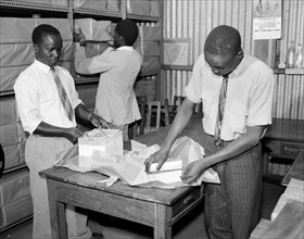 Packing books for dispatch. Promotional shot for the East African Literature Bureau. Three African