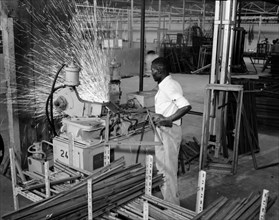 Ideal Casements worker. An African factory worker send sparks flying as he manoeuvres a metal frame