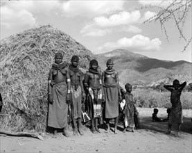 Turkana village girls. Four young Turkana women and children pictured outside a thatched village