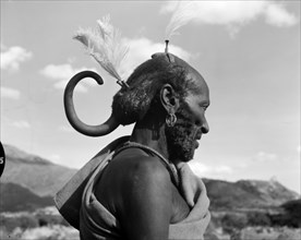 A Turkana headdress. Profile portrait of an elderly Turkana warrior, his hair braided and decorated