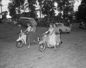 Scooters at the Royal Show. Four European women ride doubles on motor scooters at a vehicle parade