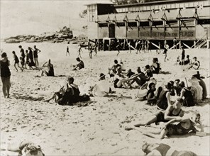 Bathers on Manley beach. Bathers wearing swimming costumes relax on the sand at Manley beach.