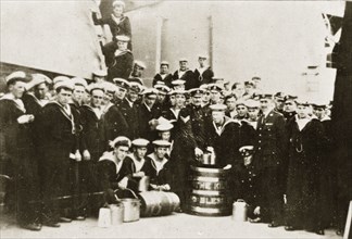 Barrel of rum. Uniformed naval personnel aboard HMS Repulse pose for a group portrait around a
