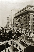 San Francisco street scene. American flags fly above a busy city street crammed with tall