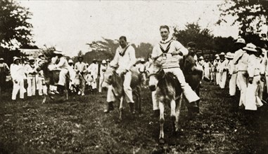 Donkey derby winning post. Uniformed sailors in the British Special Service Squadron entertain