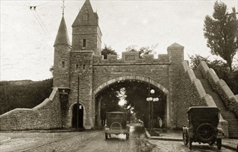 St Louis Gate, Quebec. Cars drive beneath the arched gateway and tower of St Louis Gate. Quebec,
