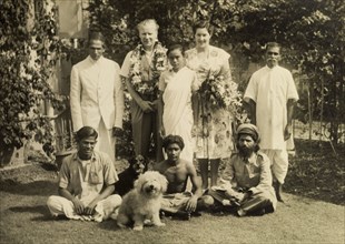 A typical a colonial household, India. Mr and Mrs Cater, adorned with flowers, pose for the camera