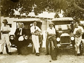 Tamlin and colleagues. Mr Alfred Tamlin (right) poses with four colleagues beside two motor