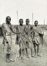 Maasai warriors, Tanganyika. Four Maasai warriors dressed in traditional dress pose for the camera,