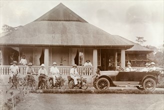 Miller Brothers' bungalow. European staff of Miller Brothers agency pose on motorbikes and in a car