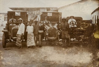 Men and cars, Western Africa. Three European drivers sit behind the wheels of their cars,