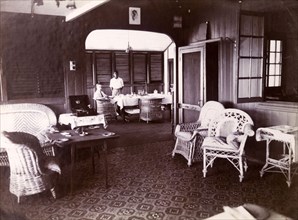 Interior of Swanzy's managers' bungalow. Alfred Tamlin and a domestic servant photographed in the