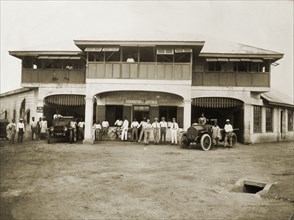 Swanzy's Motor Transport Depot. European and African staff pose with vehicles outside the Motor