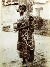 Mother and baby. Outdoors portrait of a young mother with her baby bound to her back. She wears one