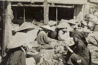 Chinese market in Burma (Myanmar). Shan traders, dressed in traditional conical hats, sit on the