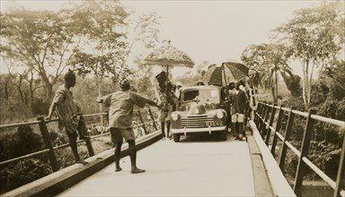 Opening of the Ishua to Ibillo bridge. People with parasols surround the first car to cross the
