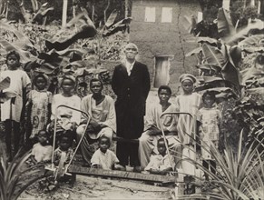 Children in 'Wasimi Garden'. Children gather around an adult male for a group photograph in 'Wasimi