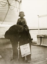 Son of Warzan'. A small boy dressed as Tarzan rides on the back of a stuffed toy elephant,