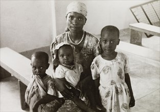 Female student of a missionary college. Portrait of an African woman with her three children, a