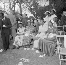 Guests at the Royal Garden Party. A group of African women dressed in Western clothing sit together