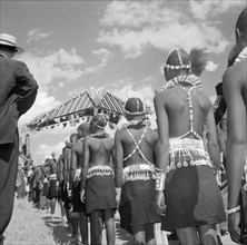 Wakamba costume from behind. Wakamba dancers stand in line with their backs to the camera during
