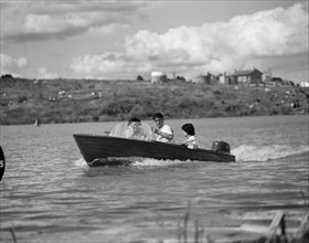 Joyriders at the Aquasports Regatta. Three youngsters take a ride in a speedboat across a lake at