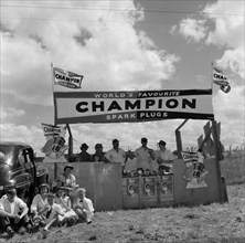 Champion spark plugs. A European family enjoy a picnic in front of the Champion stand at the