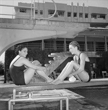 Facing the opposition. Two female swimmers competing in the 1956 Olympic Games sit facing each