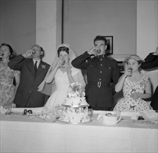 Toasting absent friends. The newlywed Jones and Buckley couple and their family drink a toast to