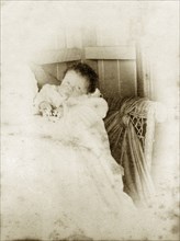 Cubbo' at two weeks, Australia. Portrait of a young baby dressed in a white gown, originally