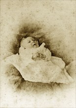 Portrait of a baby, Australia. Portrait of a young baby dressed in a white gown. Queensland,