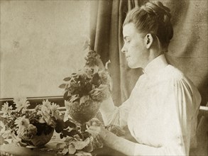Arranging flowers for a painting. Ellen May Pughe arranges daisy and rose flowers into bowls for a