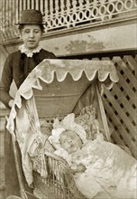 Nurse and baby at 'Nundora'. A Victorian nursemaid pushes a baby in wicker pram decorated with