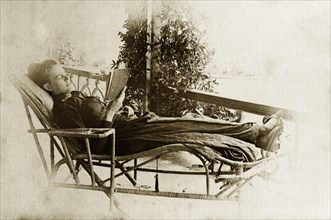 Relaxing on the veranda. Ellen May Pughe relaxes in a wicker chaise longue as she reads from a book