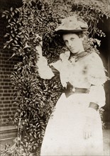 Portrait of a Victorian lady, Australia. A Victorian lady strikes a pose beside a trellis covered