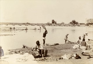 Washing clothes in the river. Indian men wash items of clothing by thrashing them onto special