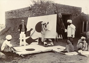 Re-covering targets. A British man instructs a group of Indian workers as they re-cover and