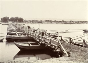 A floating bridge of canoes. A line of canoes, tethered together and permanently moored, provide