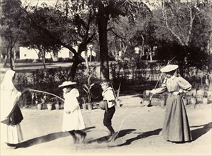 Skipping in India. Two women, one British and one Indian, swing a skipping rope in a garden for two