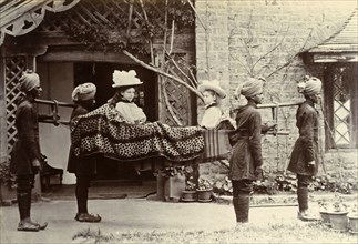 A four-anna ride'. Two British girls dressed in their best hats sit opposite each other in an open