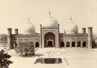 A mosque with three domes. A mosque built in typical Islamic style is decorated with features